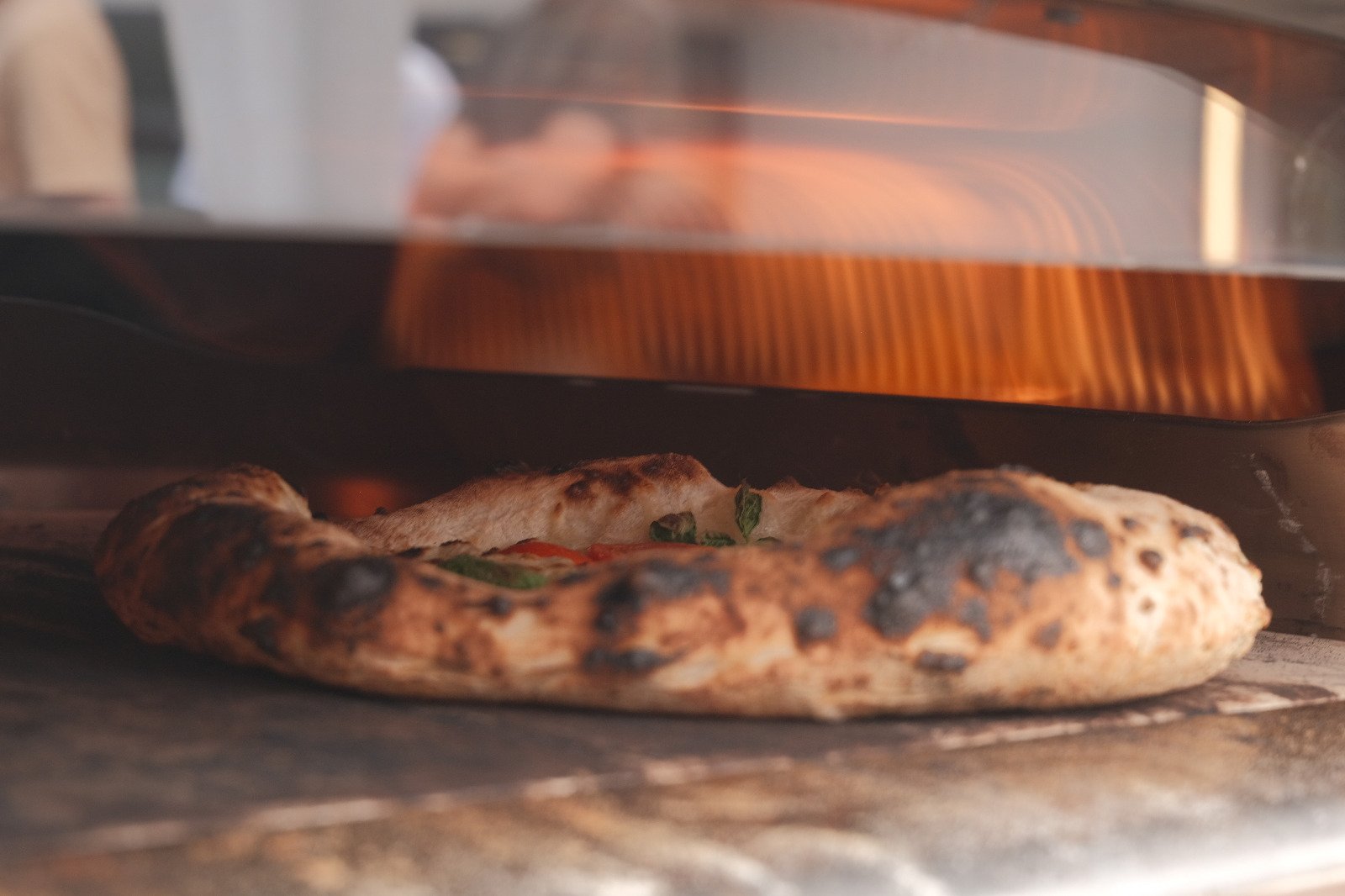 Pizza im Ooni-Ofen beim Backen, Rand mit typischer Leopardierung