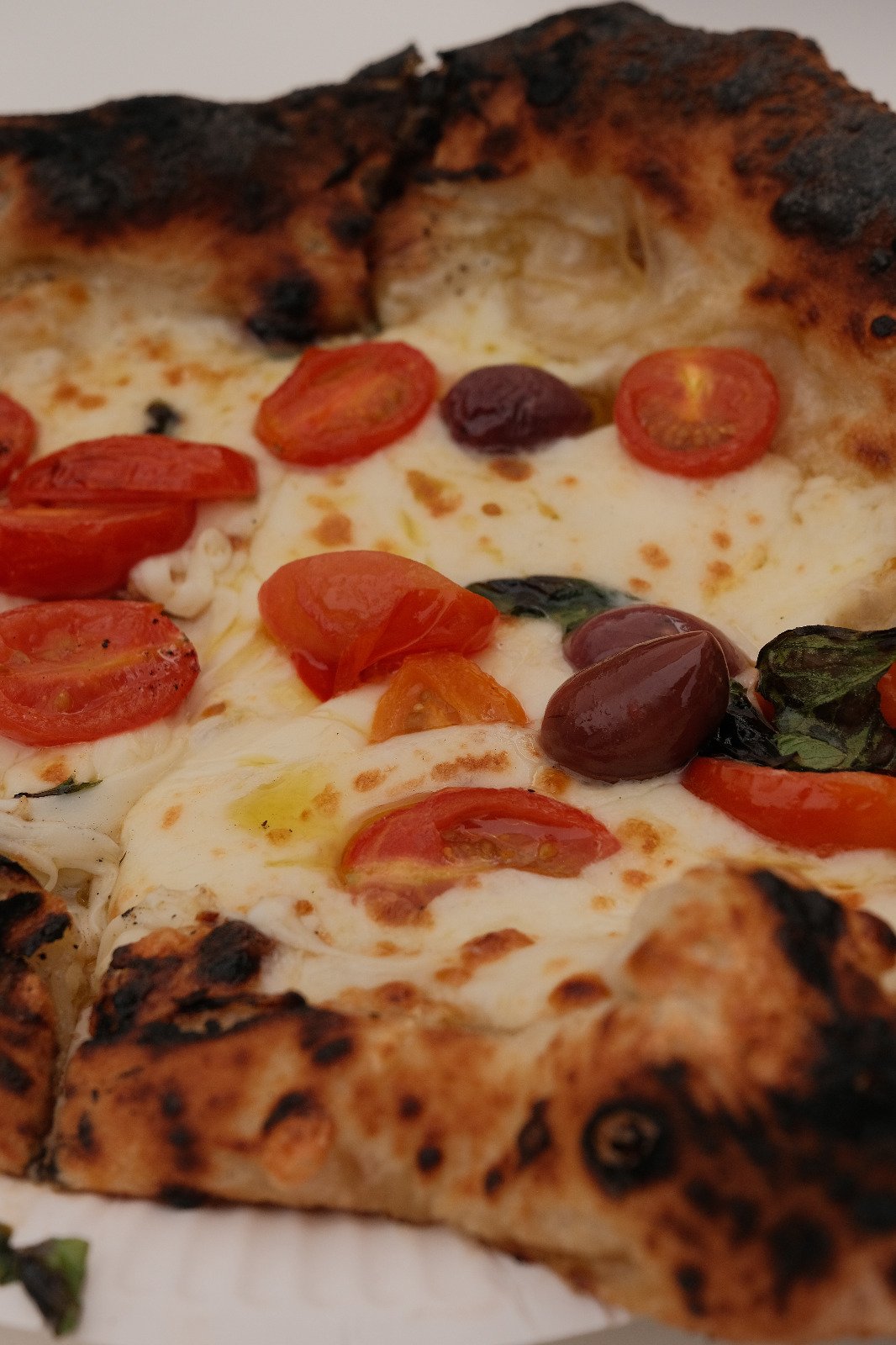 Nahaufnahme einer Margherita mit Fior di Latte, Tomaten und Oliven