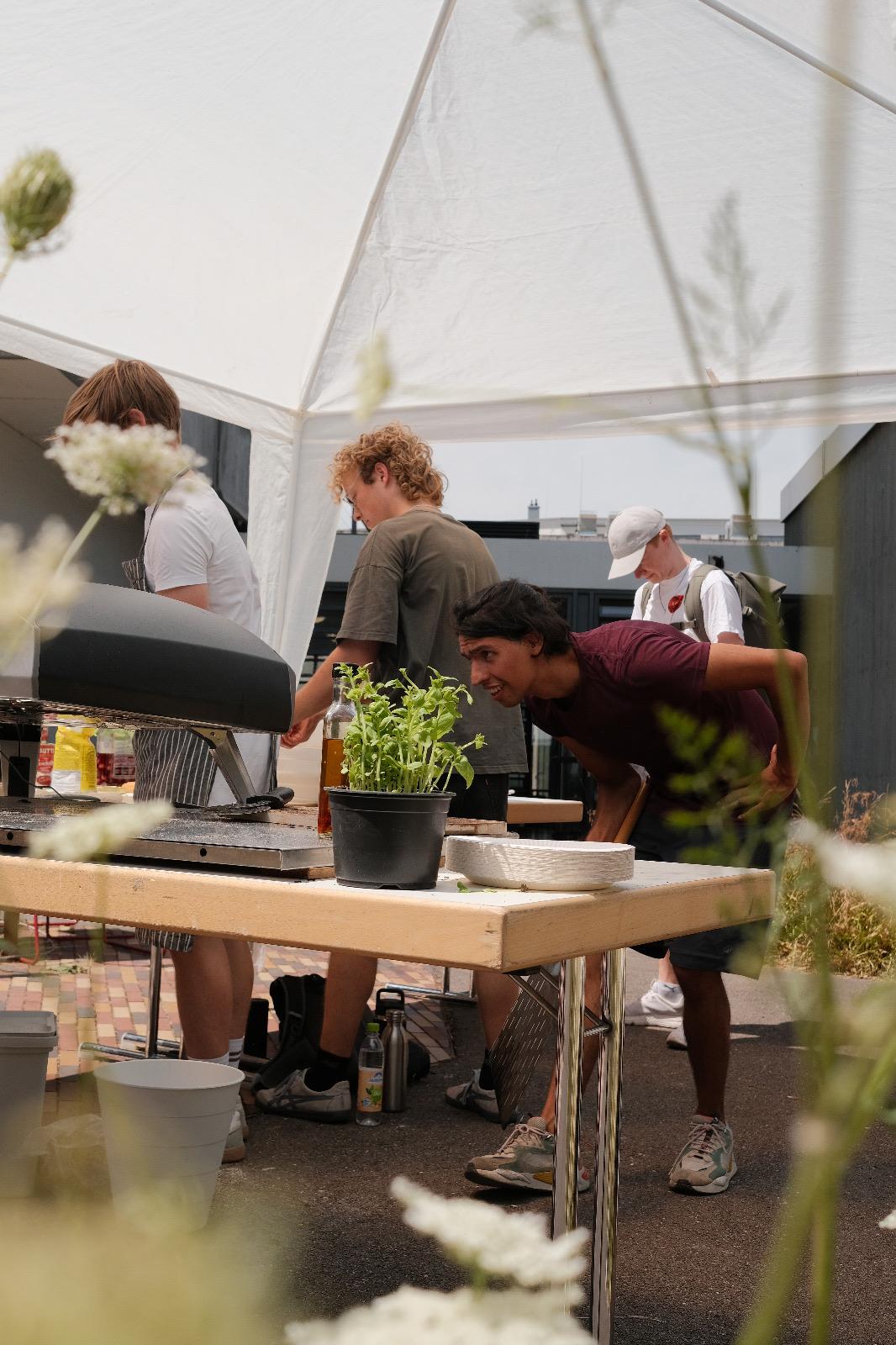 Neugieriger Blick über den Stand, im Hintergrund das Team beim Vorbereiten der Pizzen