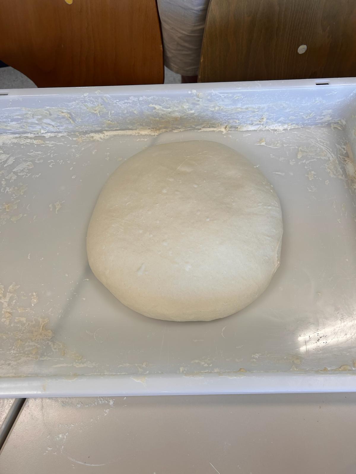 Die drei Gründer von Pizza Pazza gemeinsam am Stand mit frisch geformtem Teigballen und der Speisekarte im Hintergrund