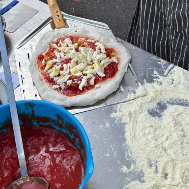 Belegte Pizza mit Fior di Latte auf dem Pizzaschieber