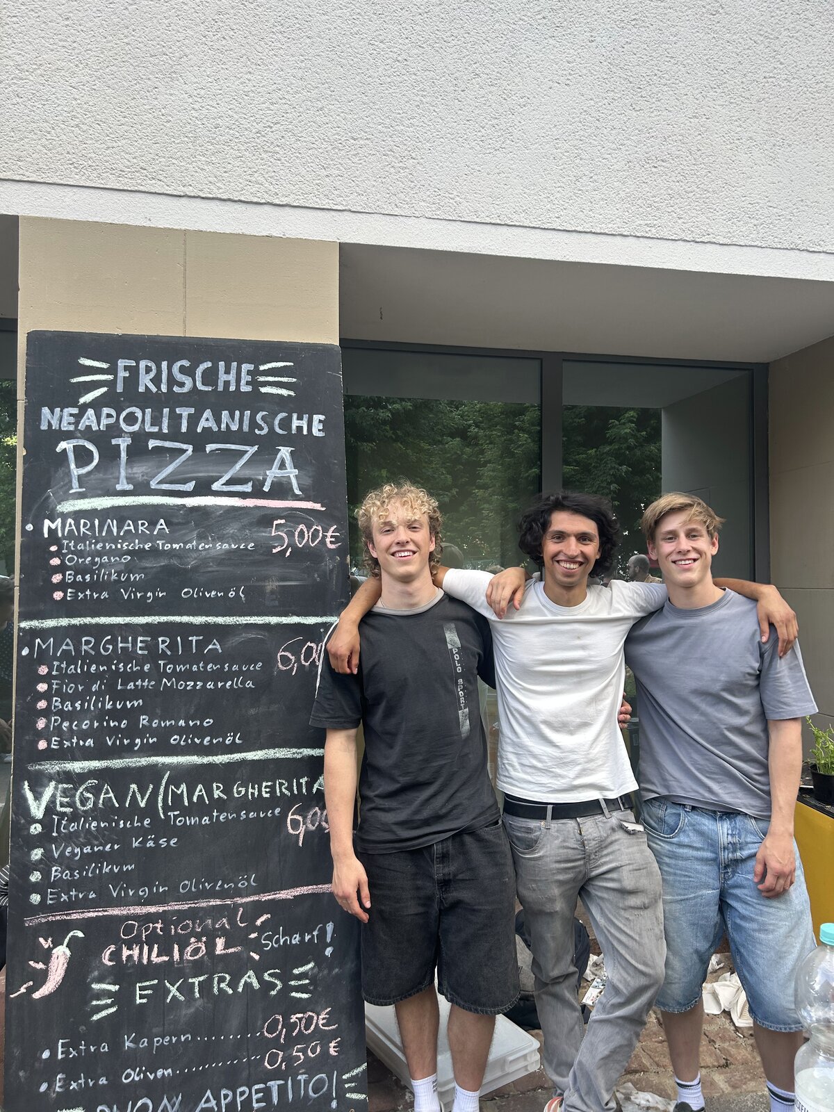 Die drei Gründer von Pizza Pazza vor ihrer Kreidetafel
